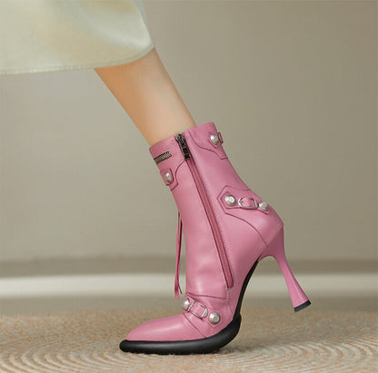 Pink high-heeled boots with decorative elements on a neutral background