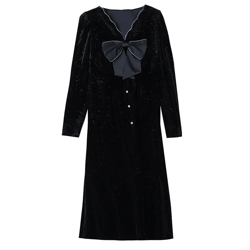 Black velvet dress with a large bow on a white background