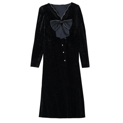 Black velvet dress with a large bow on a white background