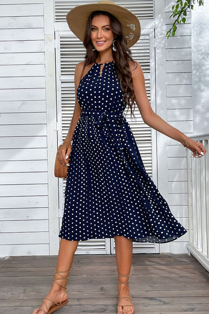 Woman wearing navy blue polka dot midi dress