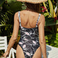 Woman wearing black & white abstract print cutout one-piece swimsuit